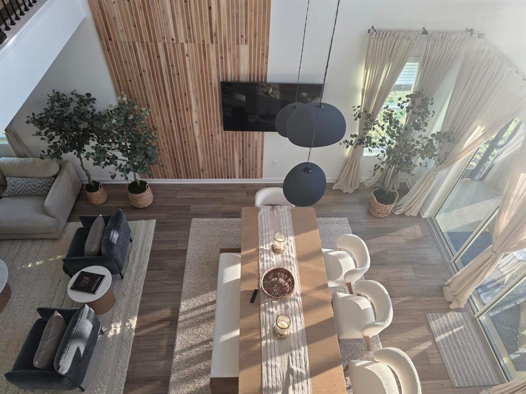 An elevated view of a living and dining area featuring wood-slat wall paneling and furniture — 1213 REUNION VILLAGE BOULEVARD, REUNION, FL