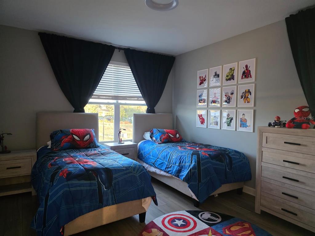 A bedroom with two twin beds, Spider-Man bedding, and a gallery wall of superhero prints — 1213 REUNION VILLAGE BOULEVARD, REUNION, FL