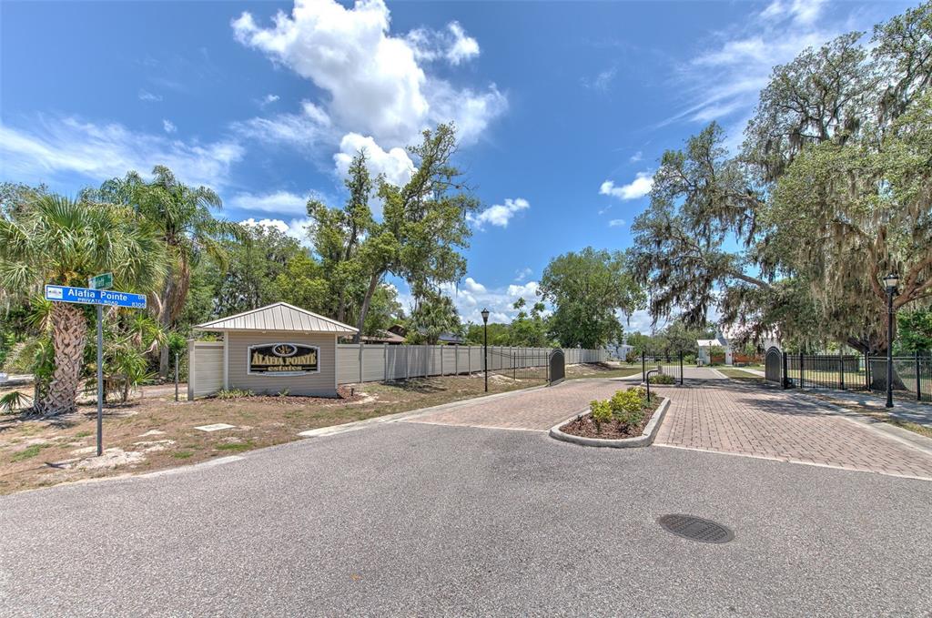The entrance to Alafia Pointe Estates features a gated driveway, a sign, and palm trees — 8325 ALAFIA POINTE DRIVE, RIVERVIEW, FL