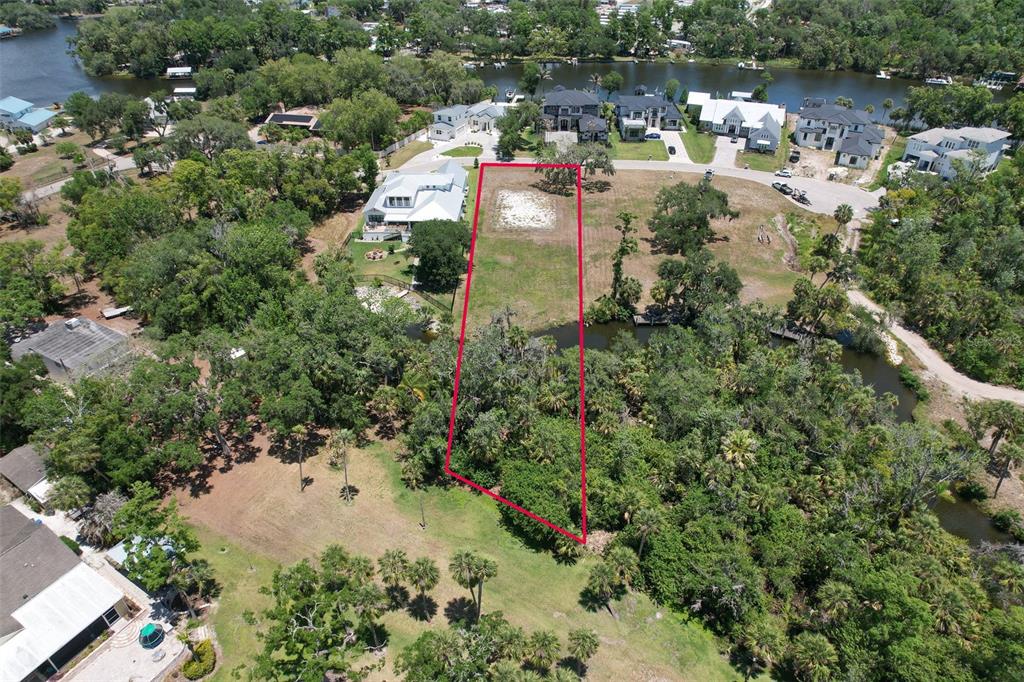 An aerial view shows a vacant, rectangular residential lot outlined in red near a waterway — 8325 ALAFIA POINTE DRIVE, RIVERVIEW, FL