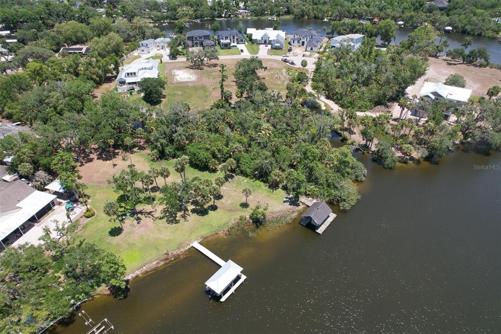 An aerial view shows a waterfront property with a dock, boat house, and surrounding trees — 8325 ALAFIA POINTE DRIVE, RIVERVIEW, FL