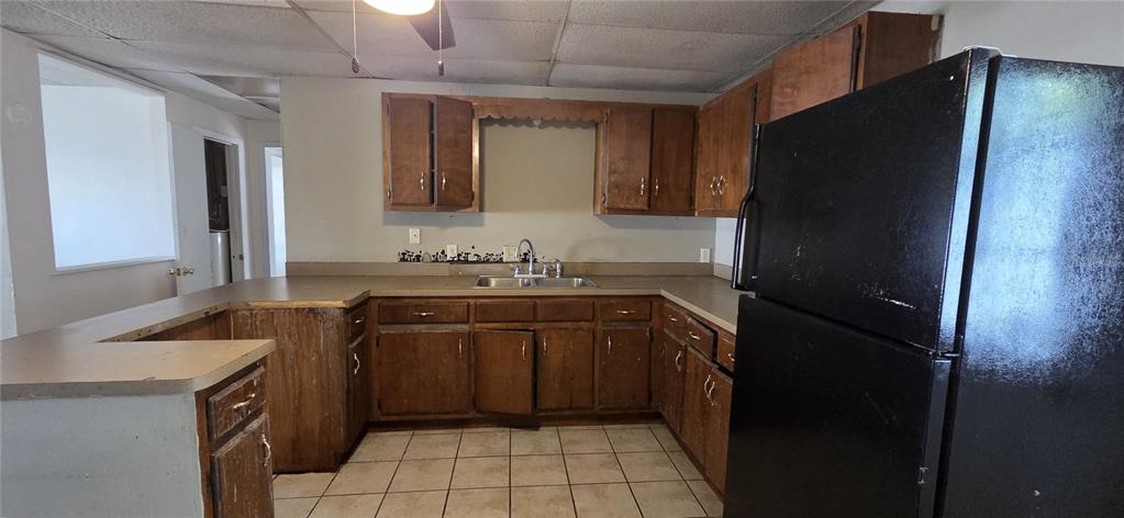 A kitchen features wood cabinets, a black refrigerator, a double sink, and tiled flooring — 205 DIXIE HIGHWAY, AUBURNDALE, FL