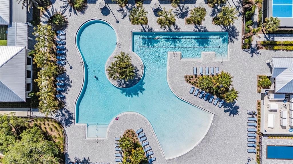 An aerial view shows a large, irregularly shaped swimming pool surrounded by lounge chairs — 16595 SHELL BAY DRIVE, LAND O LAKES, FL