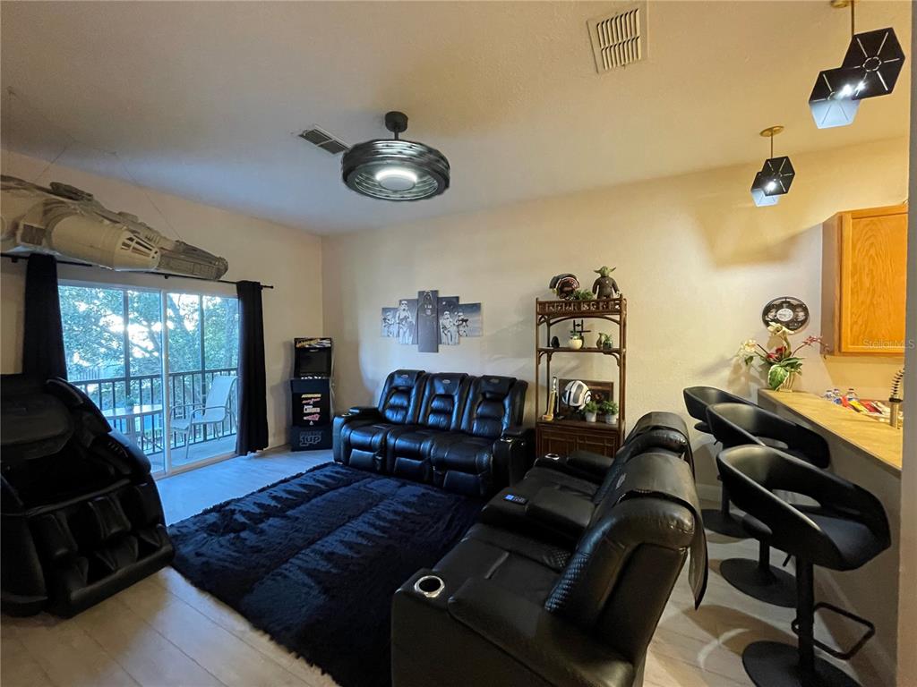 A living room features black leather recliners, a dark rug, Star Wars decor, and a bar area — 706 GRAN BAHAMA BOULEVARD UNIT 706, DAVENPORT, FL