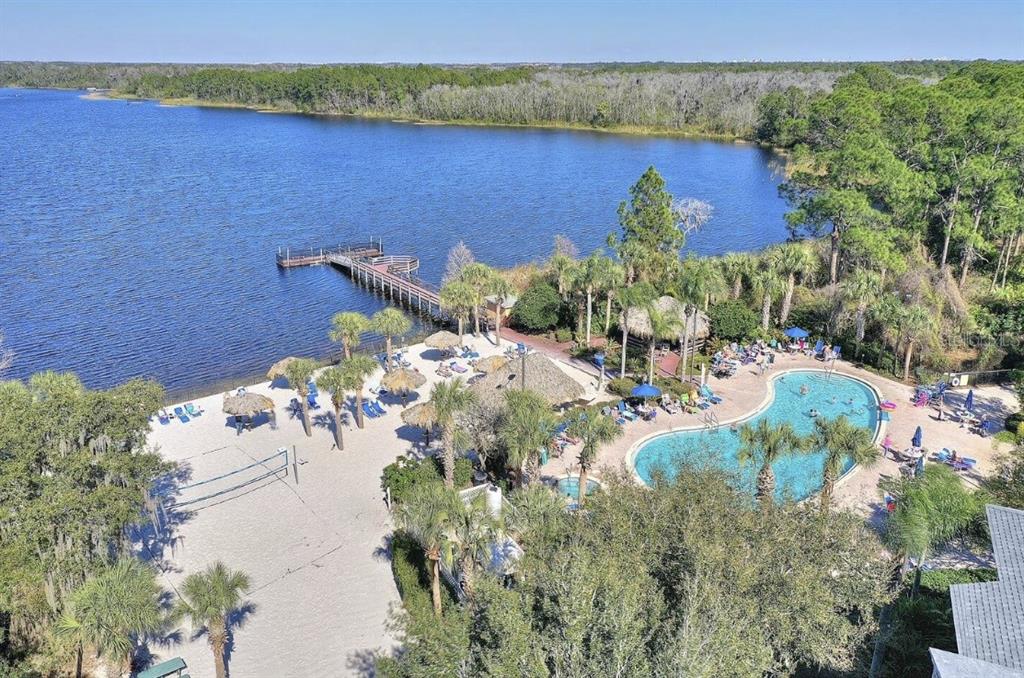 An aerial view shows a sandy beach, a swimming pool, and a wooden pier — 706 GRAN BAHAMA BOULEVARD UNIT 706, DAVENPORT, FL