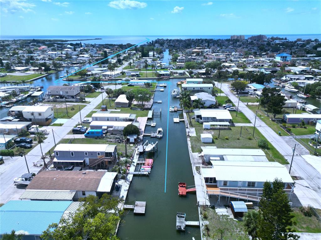 An aerial view shows a residential canal community with houses, boat docks, and blue lines — 6814 GULL LANE, HUDSON, FL