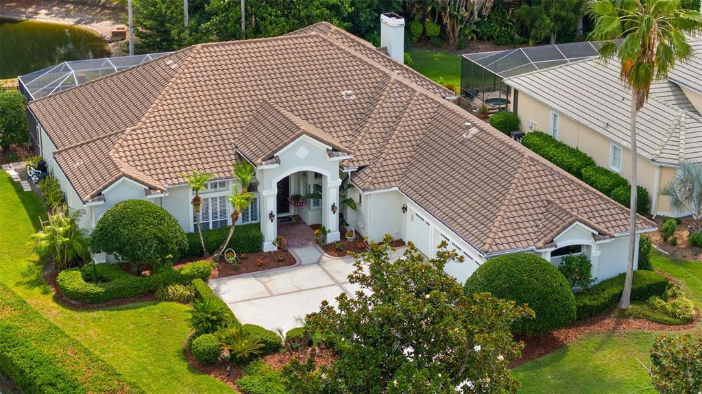 A single-story house with a tiled roof, arched entryway, and a concrete driveway — 6453 RENWICK CIRCLE, TAMPA, FL