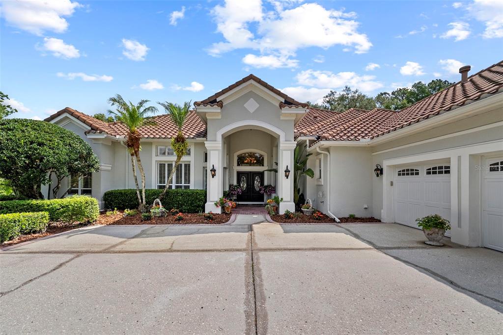 A front entryway features a brick walkway, double doors with glass inserts, and white shutters — 6453 RENWICK CIRCLE, TAMPA, FL
