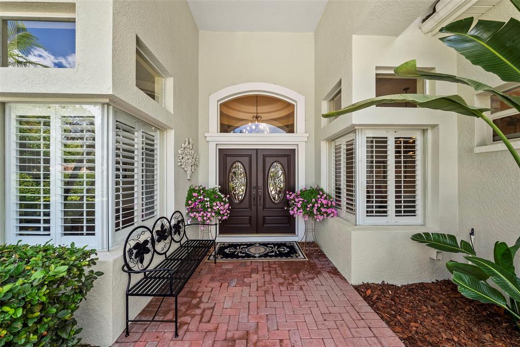 A formal living room features a tray ceiling, tile flooring, and two armchairs facing windows — 6453 RENWICK CIRCLE, TAMPA, FL
