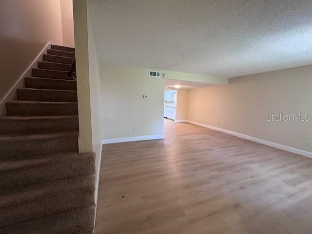 A carpeted staircase leads up beside a living area with light wood-look flooring — 916 PARK LAKE CIRCLE UNIT 34, MAITLAND, FL