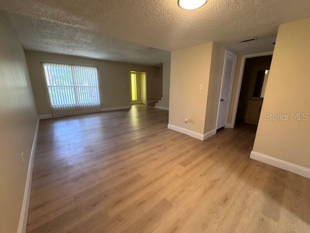 An empty room with light wood-look flooring, beige walls, and a large window with blinds — 916 PARK LAKE CIRCLE UNIT 34, MAITLAND, FL