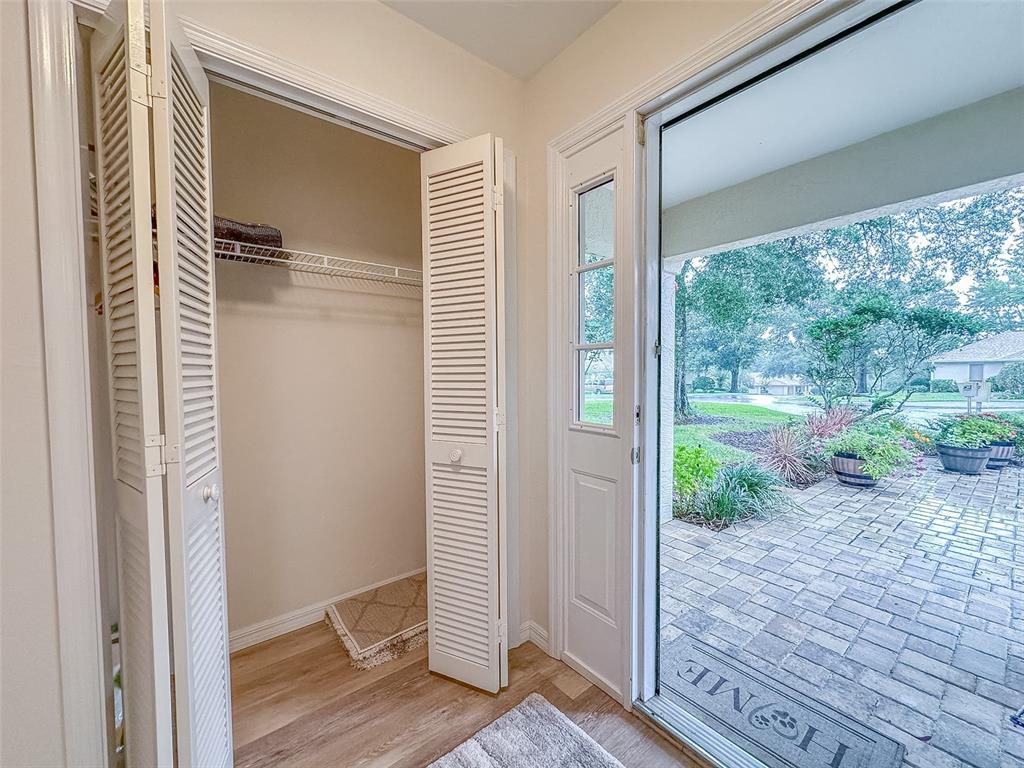 An open closet with louvered doors stands next to a doorway leading to a brick patio — 5941 W DEDHAM TRAIL, CRYSTAL RIVER, FL