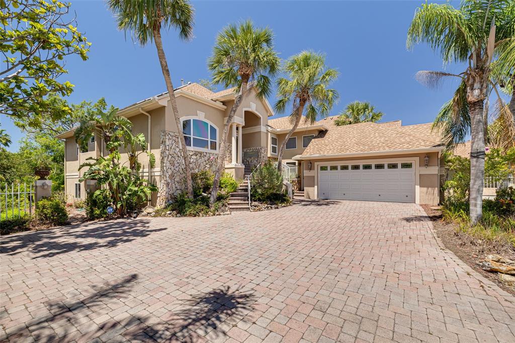 A two-story house with a stone facade, palm trees, and a paved driveway — 2613 59TH STREET S, GULFPORT, FL