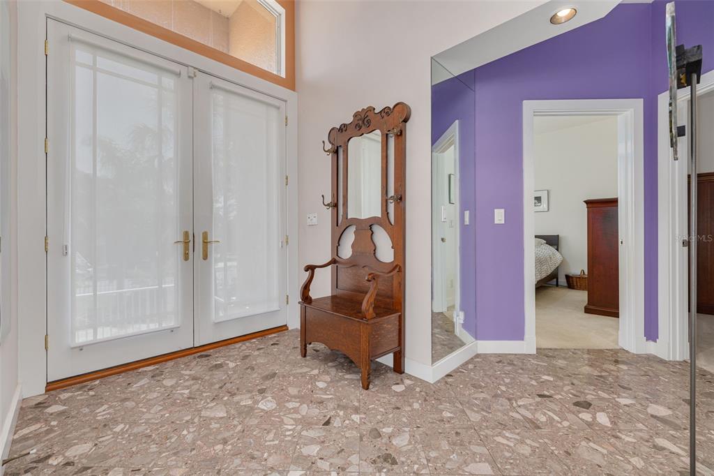A dining area with a wooden table and chairs sits before a bright living room — 2613 59TH STREET S, GULFPORT, FL