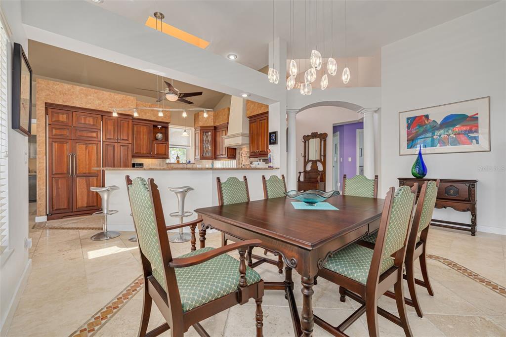 A kitchen features wood cabinetry, granite countertops, a breakfast bar with stools, and stainless appliances — 2613 59TH STREET S, GULFPORT, FL