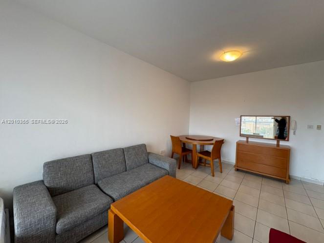 A living room features a gray sofa, a wooden coffee table, and a dining set — 27 Nicolaou Thiseos Str # 203, 8048, FL