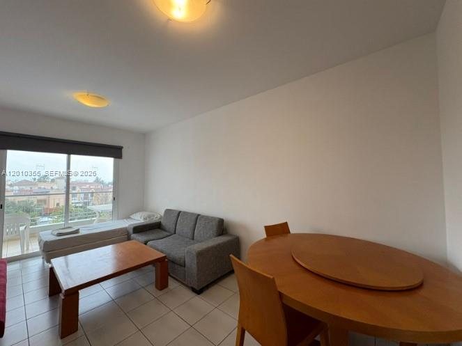 A room with tile floors features a sofa, a coffee table, and a dining set — 27 Nicolaou Thiseos Str # 203, 8048, FL