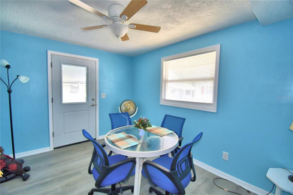 A dining area features light blue walls, a glass-top table, and four blue chairs — 4242 CEDARWOOD STREET, WINTER HAVEN, FL