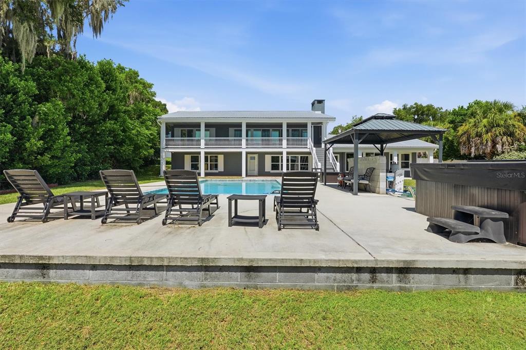 A two-story house with a pool, patio, and gazebo in the backyard — 8085 NE 310TH AVENUE, FORT MC COY, FL
