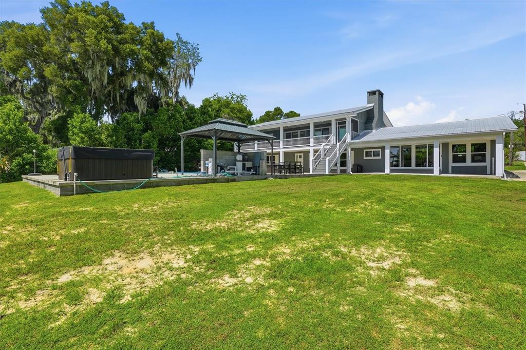 A two-story house with a metal roof, a hot tub, and a gazebo on the lawn — 8085 NE 310TH AVENUE, FORT MC COY, FL