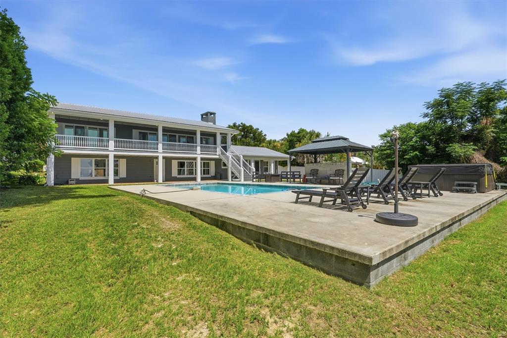 A two-story house with a backyard pool, concrete patio, and a covered gazebo — 8085 NE 310TH AVENUE, FORT MC COY, FL