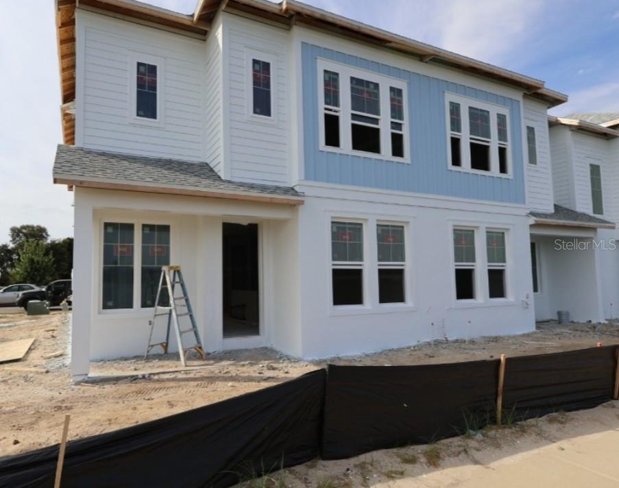 A two-story house under construction features white siding, blue vertical accents, and multiple windows — 7199 TIDELAND LANE, SARASOTA, FL