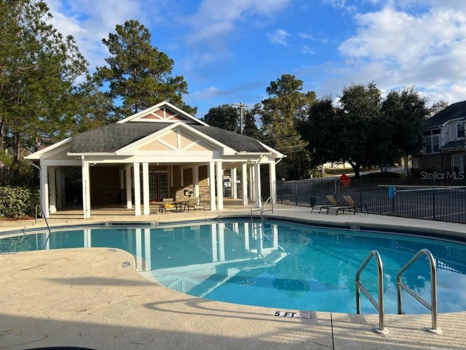 A swimming pool sits in front of a covered clubhouse with white columns — 2288 DEL CARMEL WAY UNIT 14, TALLAHASSEE, FL