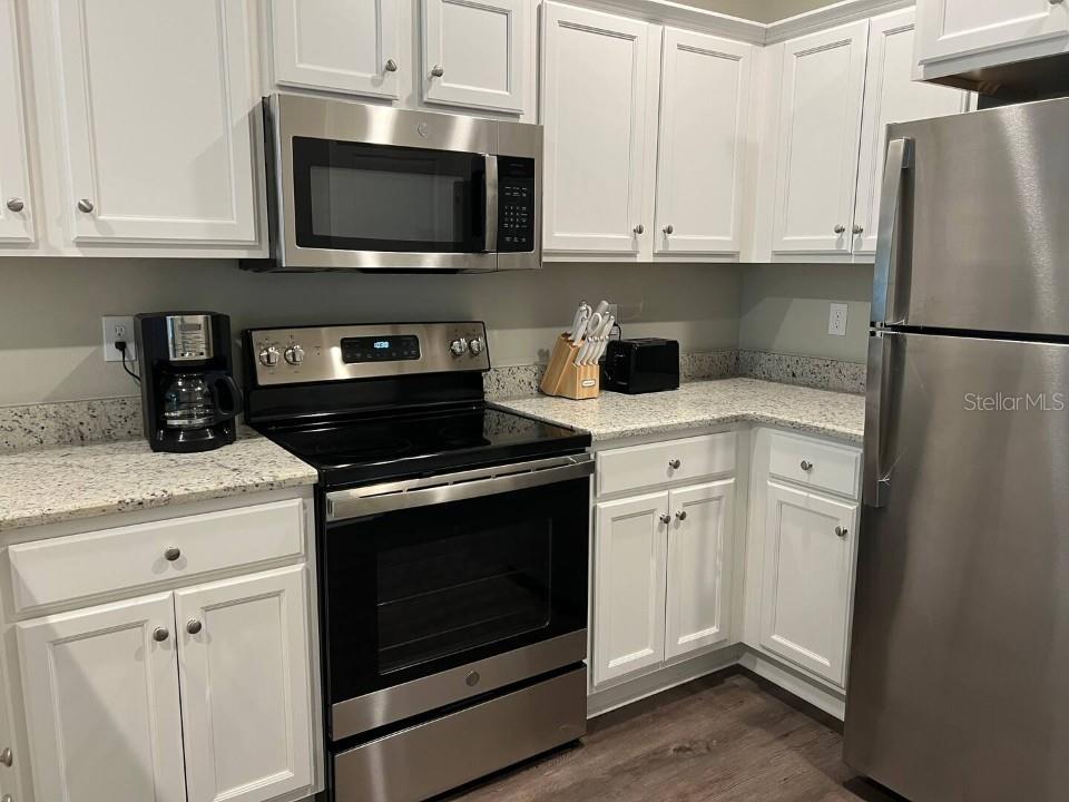 A kitchen features white cabinets, stainless steel appliances, and speckled granite countertops — 2288 DEL CARMEL WAY UNIT 14, TALLAHASSEE, FL