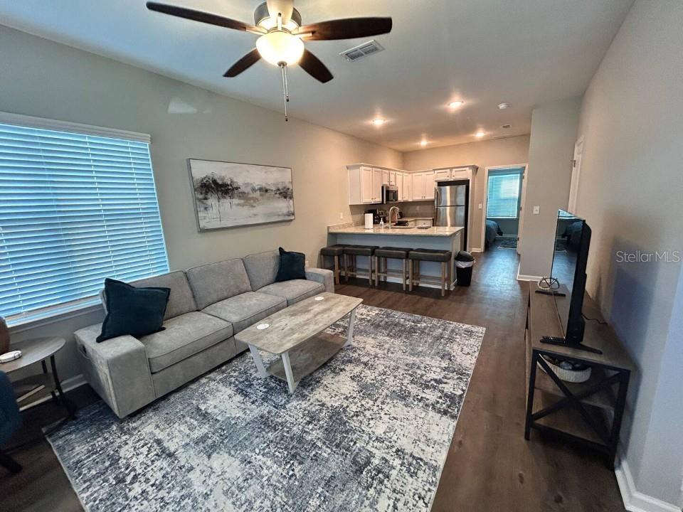A living room with a gray sofa, area rug, and an open kitchen with bar seating — 2288 DEL CARMEL WAY UNIT 14, TALLAHASSEE, FL