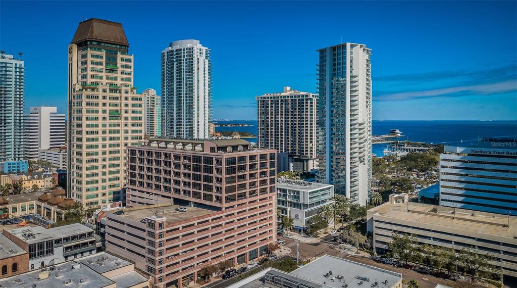 An aerial view of a city skyline featuring several high-rise buildings and a parking garage — 175 2ND STREET S UNIT P04, ST PETERSBURG, FL