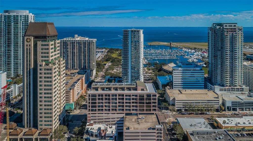 An aerial view of a city skyline featuring high-rise buildings, a marina, and the ocean — 175 2ND STREET S UNIT P04, ST PETERSBURG, FL
