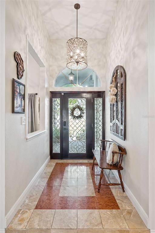 An entryway features a patterned tile floor, a decorative pendant light, and a wooden bench — 4571 KAWILLA CREST PLACE, WINTER PARK, FL
