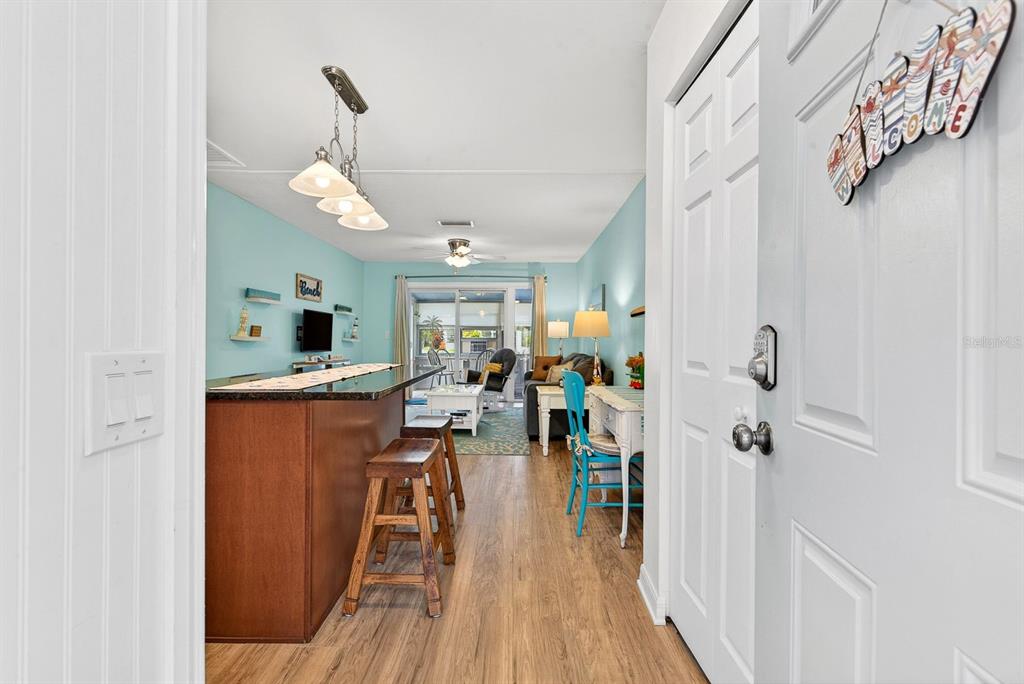A view from an entryway into a living area with a bar and light blue walls — 5055 LIVE OAK CIRCLE UNIT 5055, BRADENTON, FL