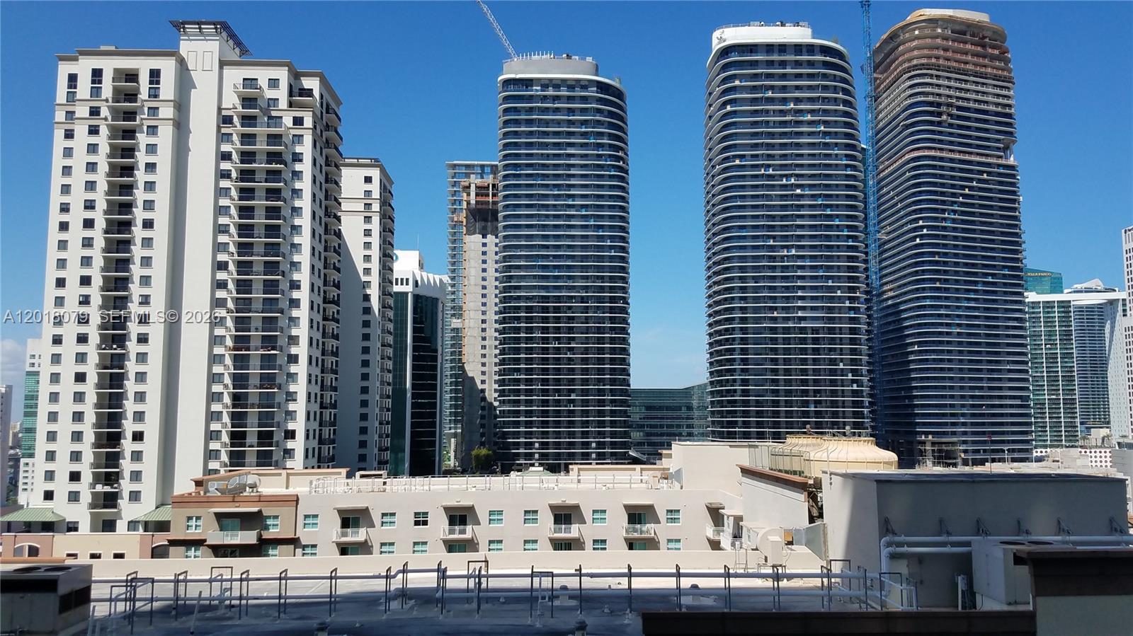 An exterior view shows several tall, modern residential high-rise buildings under a clear blue sky — 1111 SW 1st Ave, Miami FL 33130, MIAMI, FL