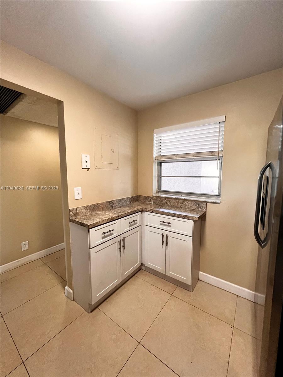A small kitchen corner features white cabinets, a brown laminate countertop, and a window — 9235 Lagoon Pl # 109, Davie FL 33324, DAVIE, FL
