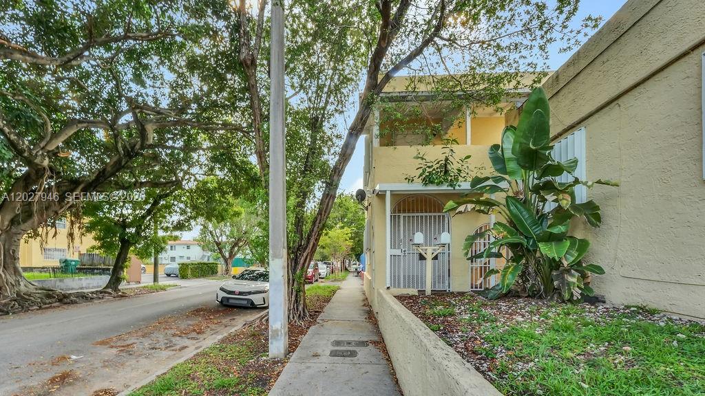 A two-story yellow apartment building sits beside a sidewalk and a tree-lined street — 242 SW 15th Ave, Miami FL 33135, MIAMI, FL