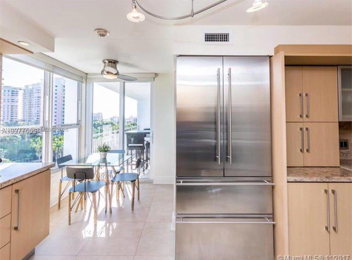 A kitchen features stainless steel appliances, light wood cabinetry, and a dining area with views — 607 Ocean Dr # 9K, Key Biscayne FL 33149, KEY BISCAYNE, FL