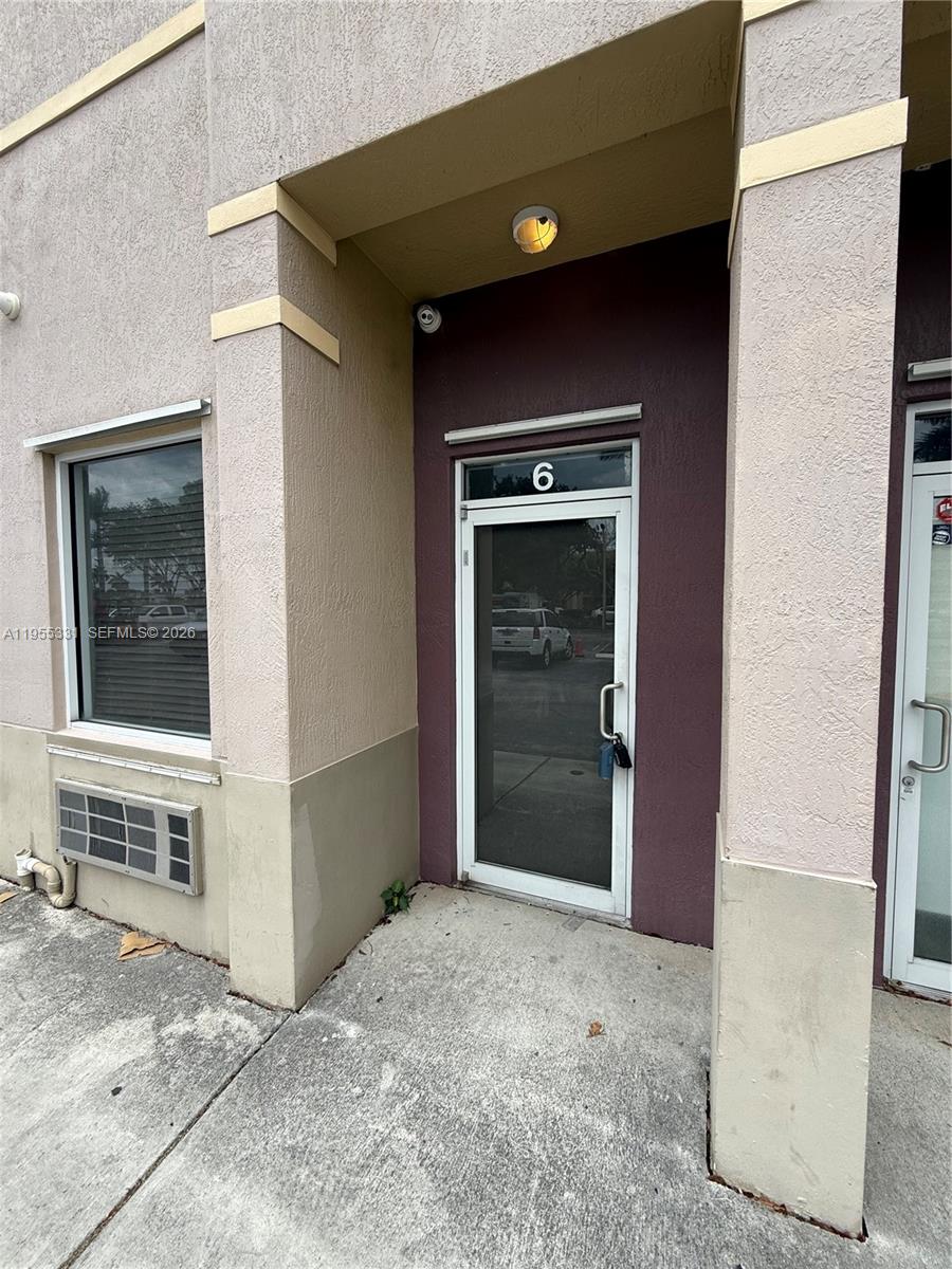 The exterior of a commercial building entrance features a glass door labeled number six — 15075 SW 137th St # 6, Miami FL 33196, MIAMI, FL