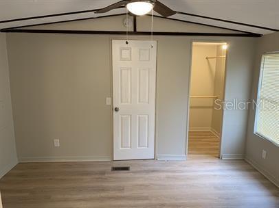 A bedroom with light-colored walls, wood-look flooring, a ceiling fan, a closet, and a window — 7032 SE 170TH AVENUE ROAD, OCKLAWAHA, FL