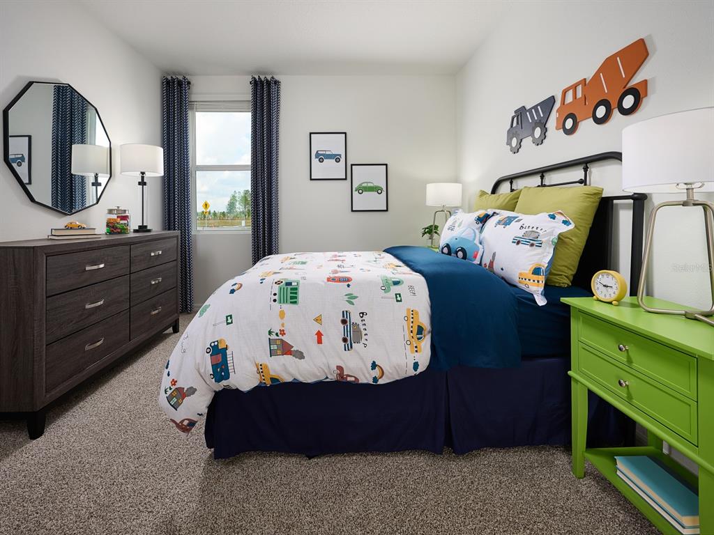 A child's bedroom features a bed with vehicle-themed bedding, a green nightstand, and a dresser — 2057 ROSEWOOD DRIVE, BARTOW, FL