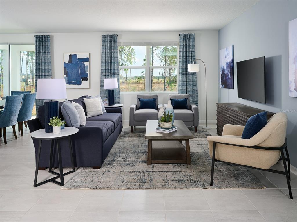 A living room features a blue sofa, two gray armchairs, and a beige accent chair — 2057 ROSEWOOD DRIVE, BARTOW, FL