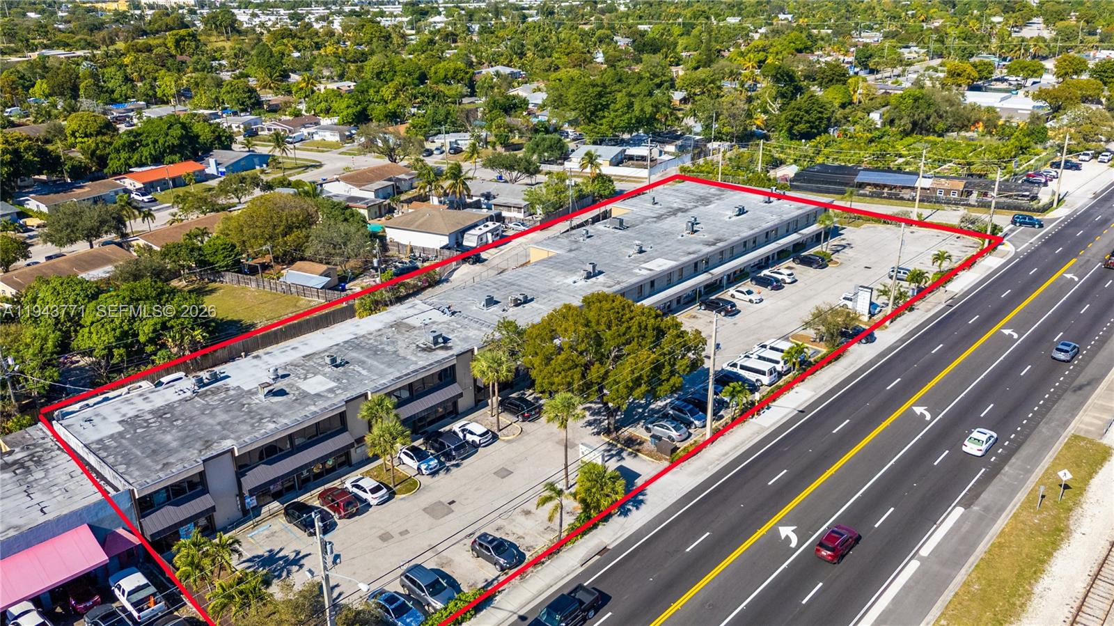 An aerial view shows a long, two-story commercial building with a parking lot along a highway — 2025 N Dixie Hwy, Pompano Beach FL 33060, POMPANO BEACH, FL