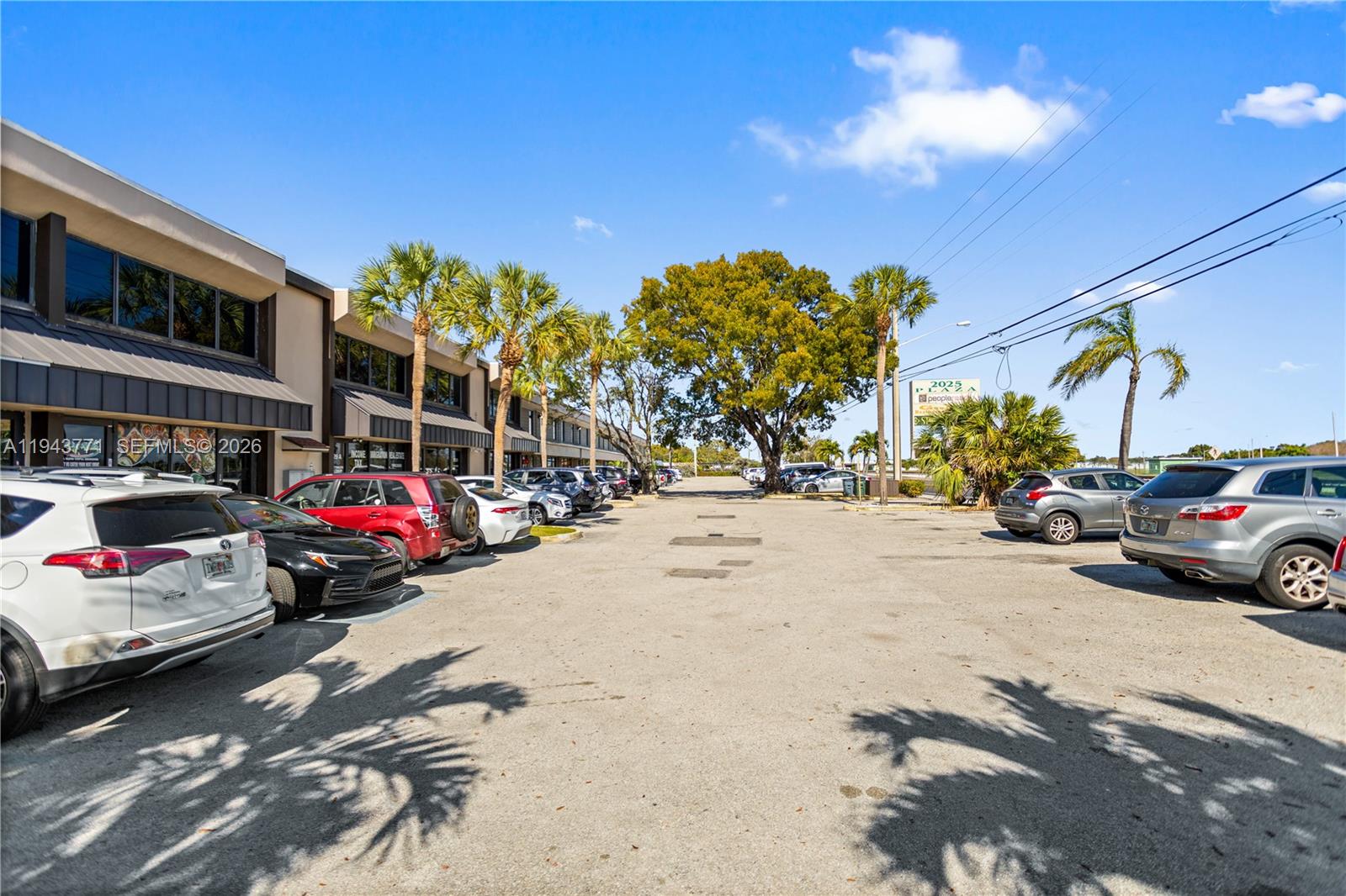A parking lot sits in front of a two-story commercial building with palm trees — 2025 N Dixie Hwy, Pompano Beach FL 33060, POMPANO BEACH, FL