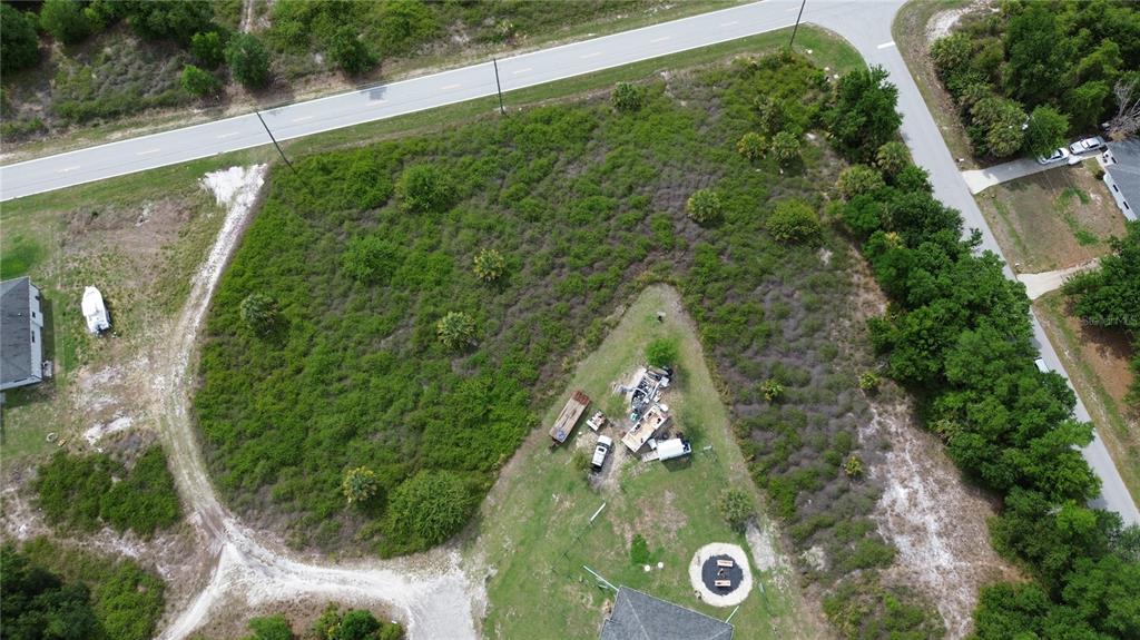 An aerial view shows a large, partially wooded vacant lot bordered by two paved roads — 2065 CHAPLIN DRIVE, PUNTA GORDA, FL