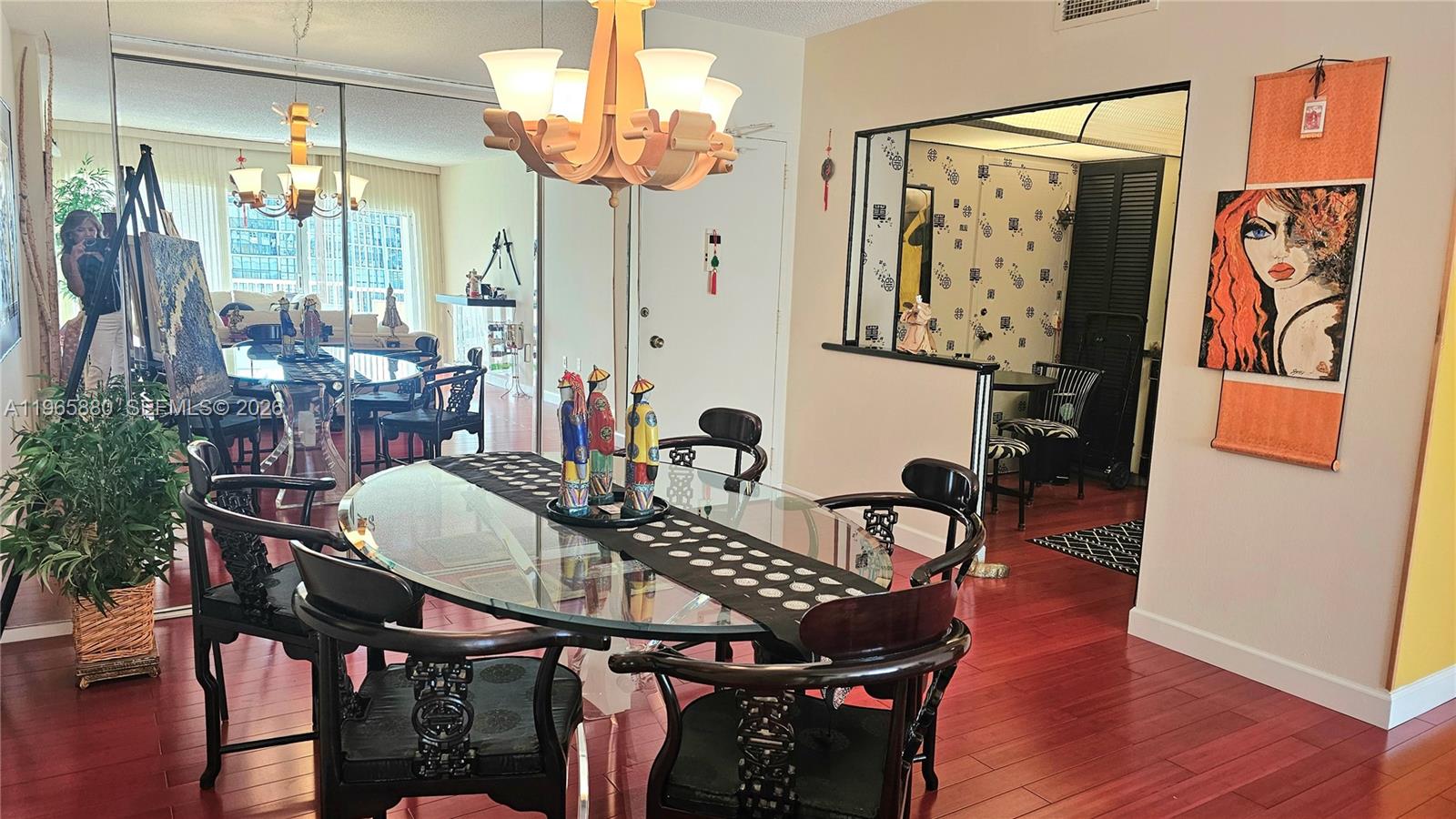 A dining room features a glass-topped table, dark wooden chairs, and hardwood flooring — 1985 S Ocean Dr # 10J, Hallandale Beach FL 33009, HALLANDALE BEACH, FL
