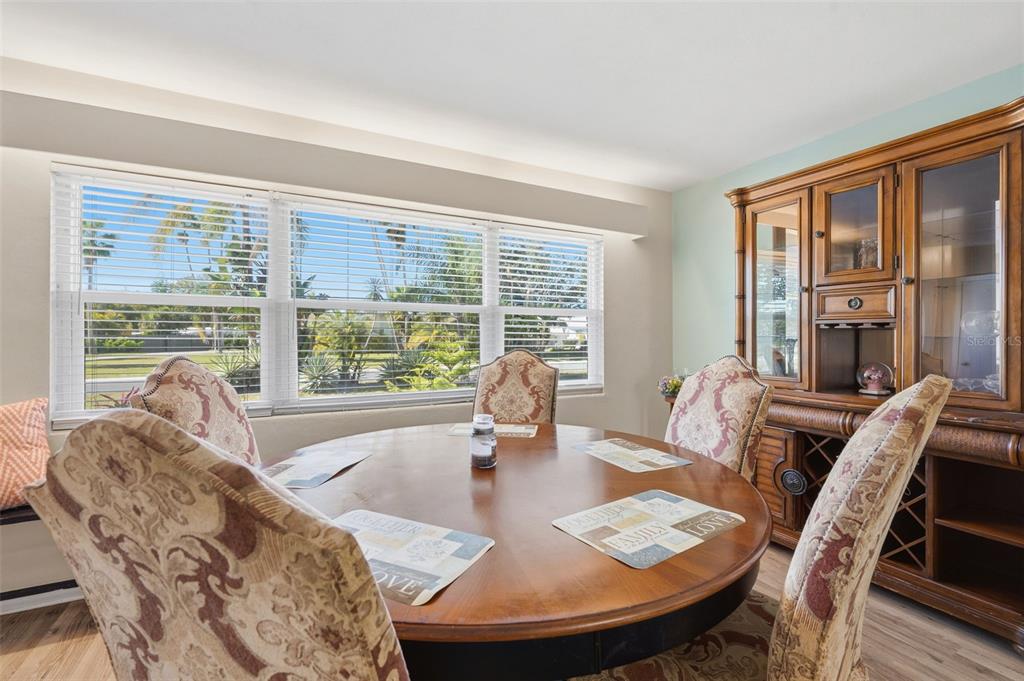 A dining room features a round wooden table, patterned chairs, and a large wooden hutch — 610 PALM AVENUE, BELLEAIR, FL