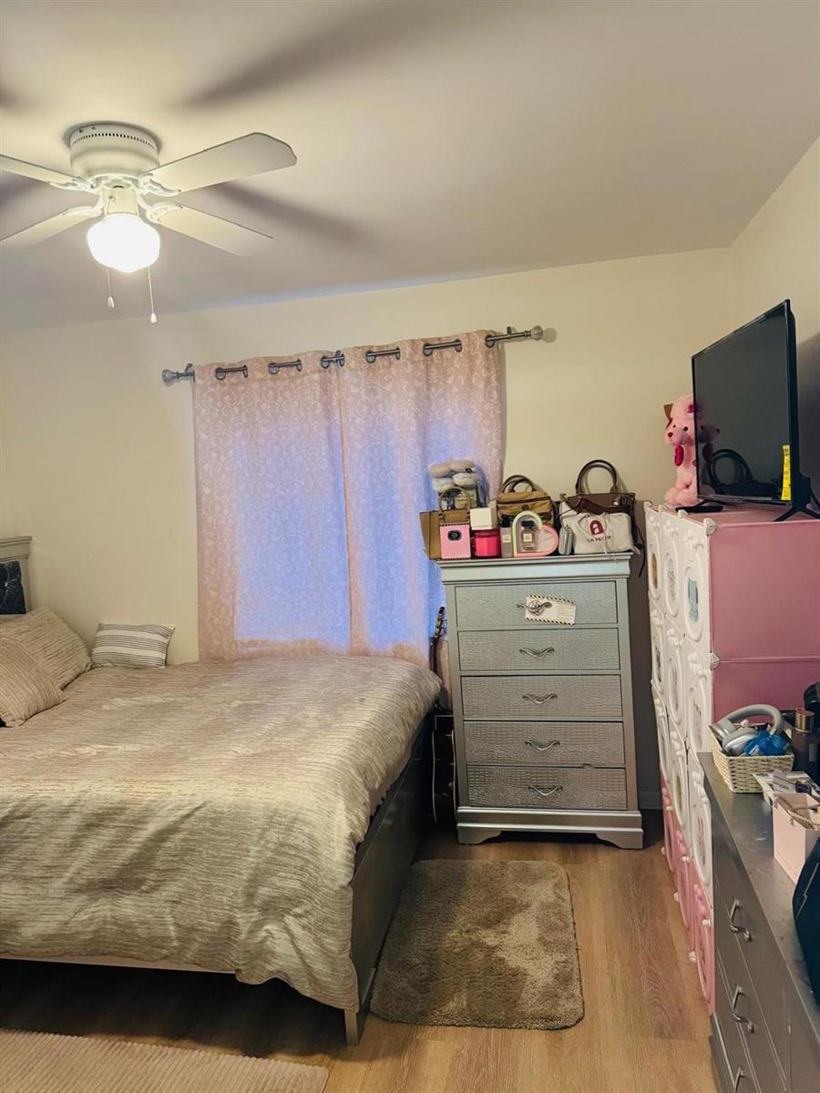 A bedroom features a bed, a silver dresser, a pink storage unit, and a ceiling fan — 958 W 4th Street, Riviera Beach FL 33404, RIVIERA BEACH, FL
