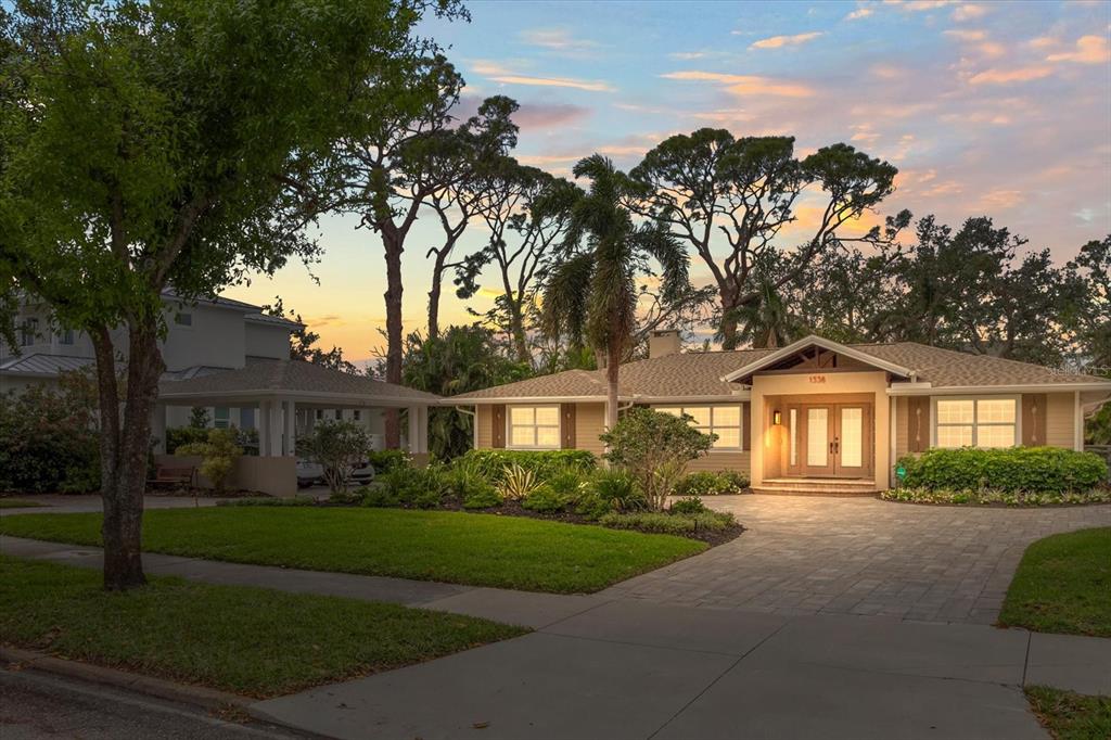 A single-story house with a paved driveway, a carport, and a landscaped front yard at sunset — 1538 S ORANGE AVENUE, SARASOTA, FL