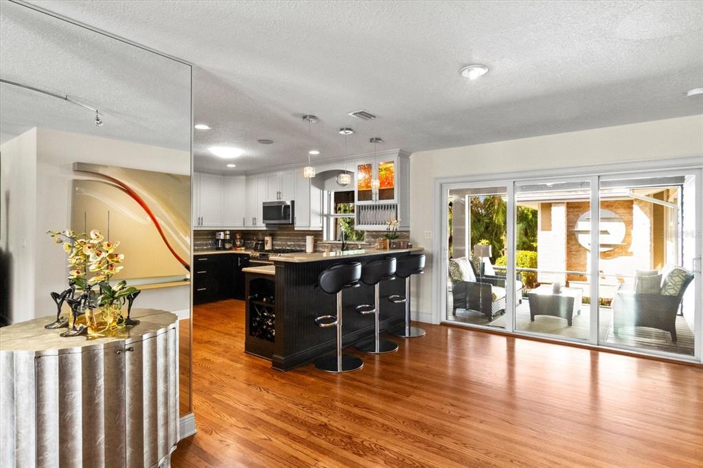 A kitchen with dark cabinets and a breakfast bar opens to a patio through glass doors — 1538 S ORANGE AVENUE, SARASOTA, FL