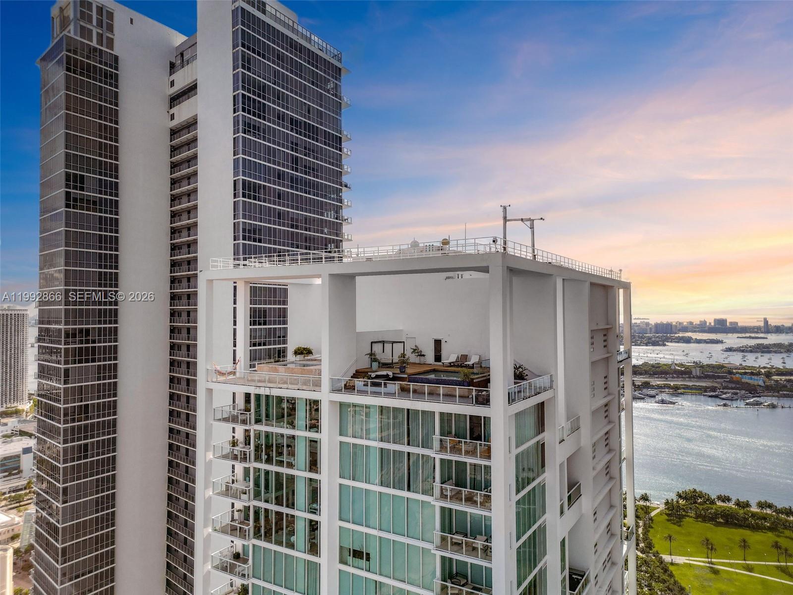 An aerial view shows a high-rise building with a rooftop terrace featuring a pool — 1040 Biscayne Blvd # 4607, Miami FL 33132, MIAMI, FL